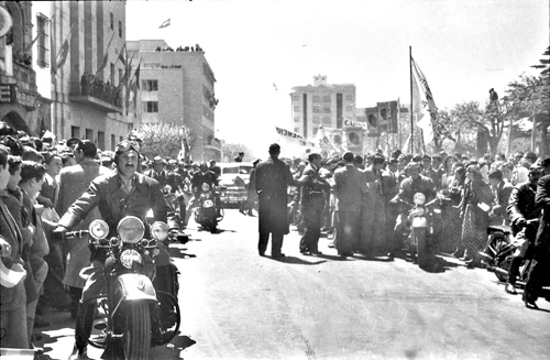 El automóvil que traslada a Eva Perón llega a la Municipalidad, custodiado por motociclistas.