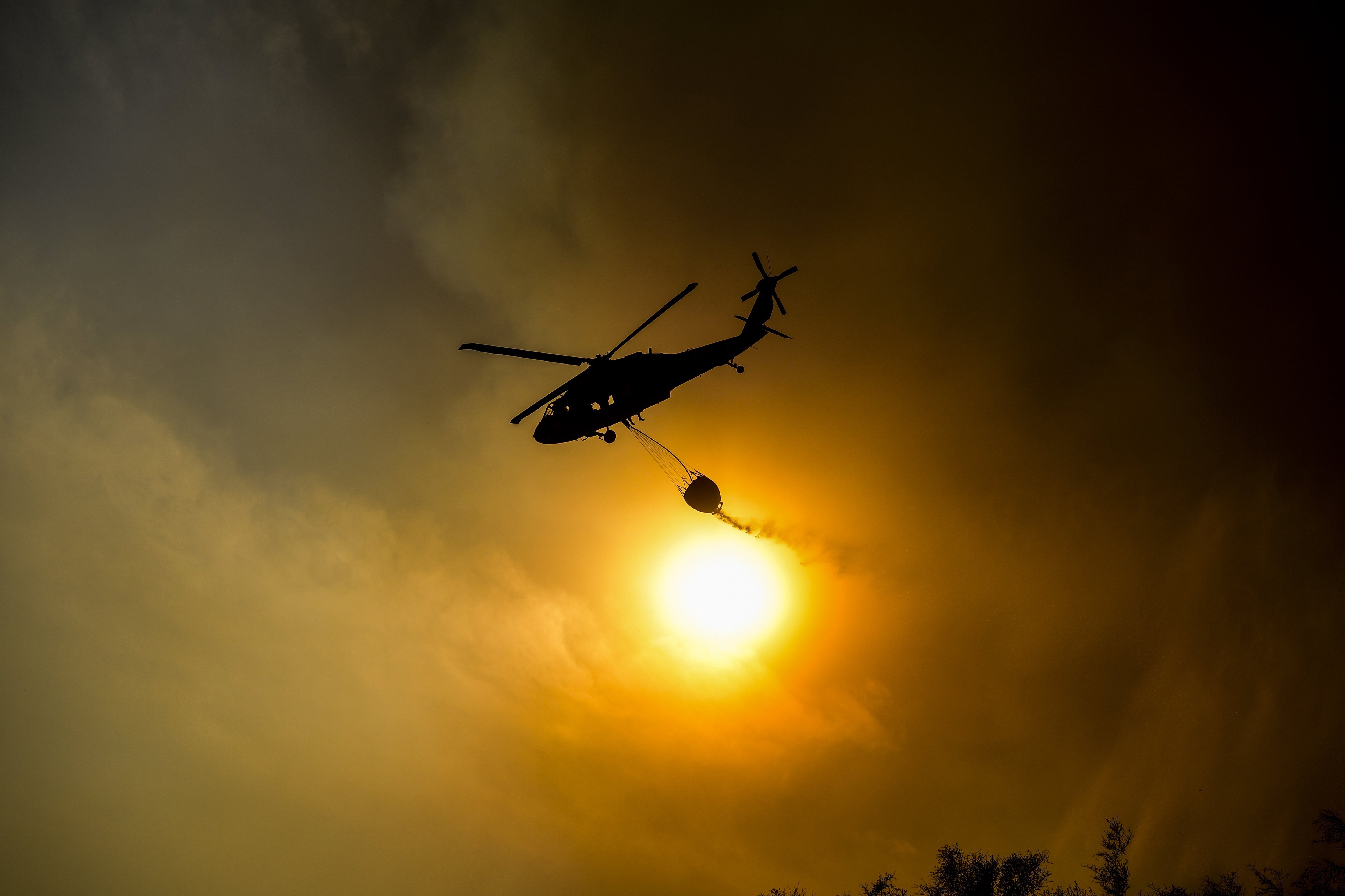 MCX03. Ojai (United States), 09/12/2017.- A firefighting helicopter dropps water on an afflicted area as efforts to battle the Thomas Fire were under way in Ojai, California, USA, 09 December 2017 (issued 23 December 2017). The Thomas Fire, which began 04 December, has now become the largest wildfire in California history at 273,400 acres (110,641 hectares) and caused, on 14 December, the death of a firefighter. Officials estimate they will not contain the fire until 07 January 2018. (Incendio, Estados Unidos) EFE/EPA/JOHN CETRINO
