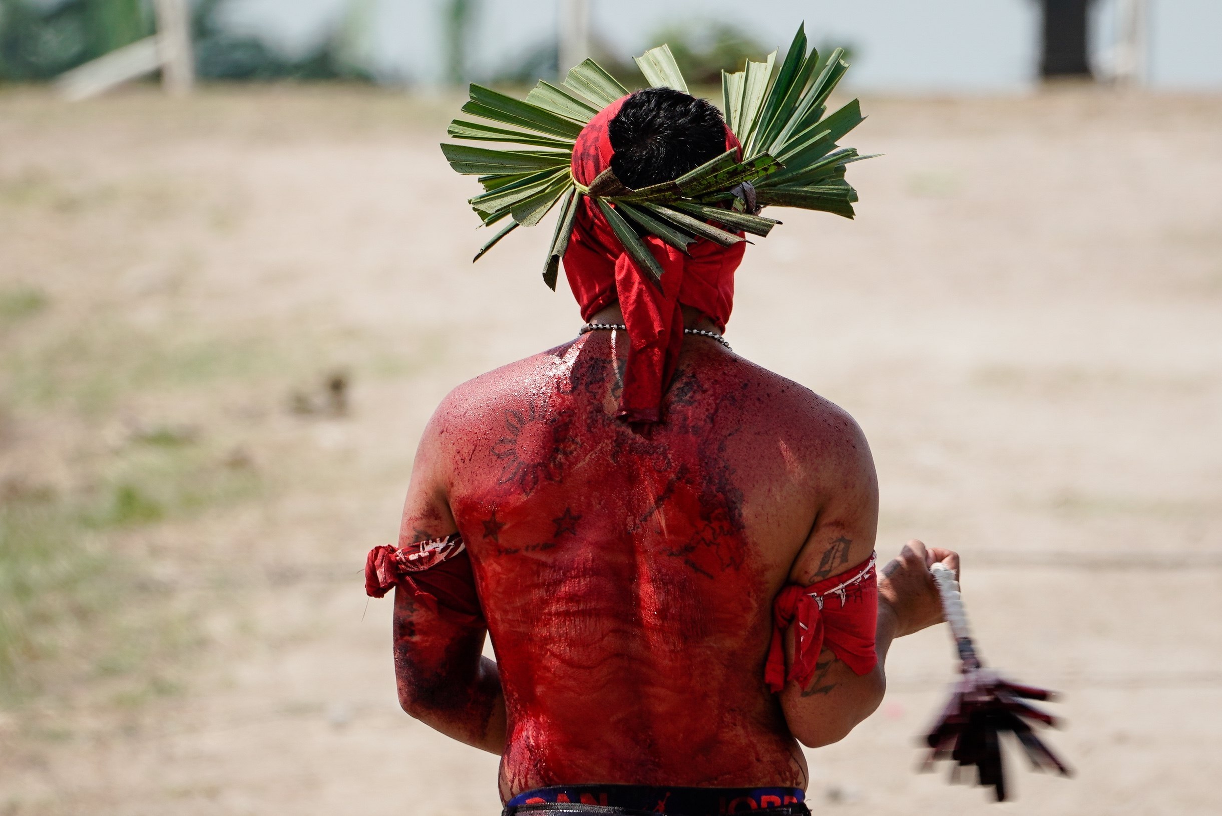 Un flagelante azota su espalda en la celebración del Viernes Santo en el pueblo de San Pedro. Foto: EFE | Mark R. Cristino.