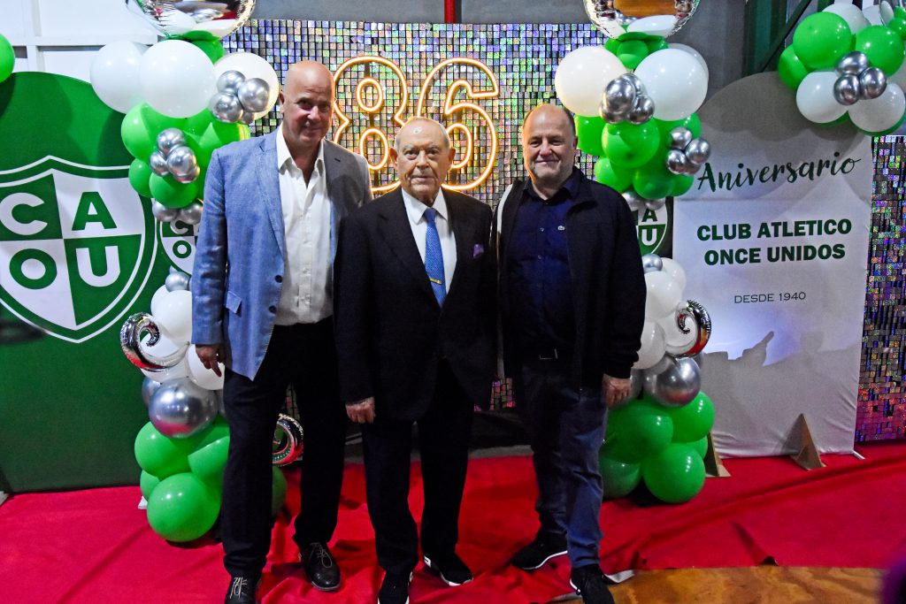 Horacio Taccone -presidente- y Eduardo Gersini -vicepresidente- junto al empresario Florencio Aldrey y el back que certifica los 86 años.