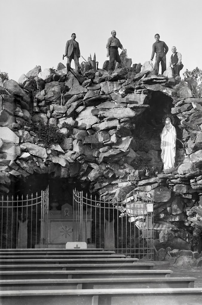 Obreros construyendo, piedra sobre piedra, la Gruta de Lourdes.
