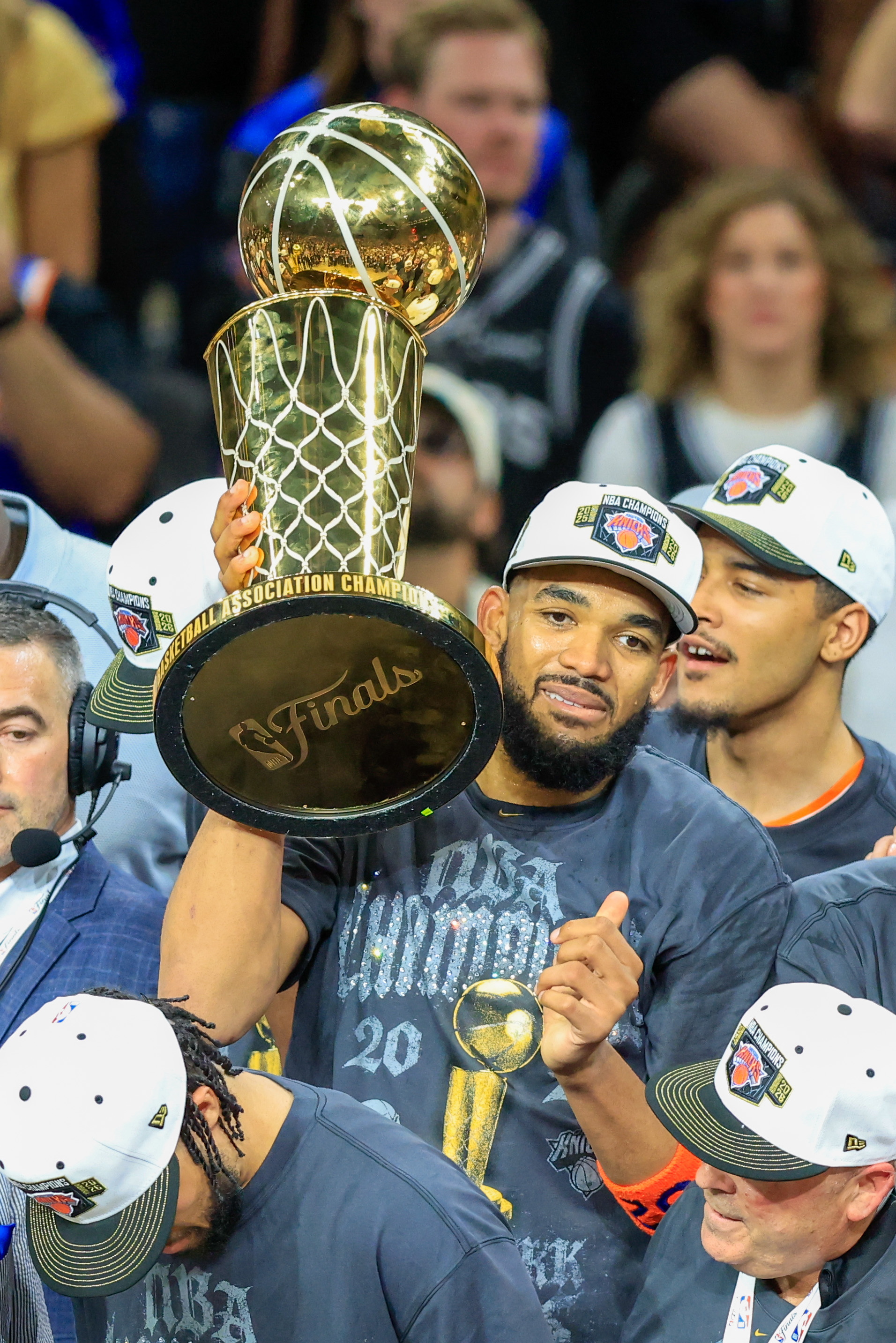 El pivote de los New York Knicks, Karl-Anthony Towns, sostiene el trofeo Larry O'Brien tras ganar el quinto partido de las Finales de la NBA entre los Spurs y los Knicks, en San Antonio. Foto: EFE | EPA | Adam Davis.