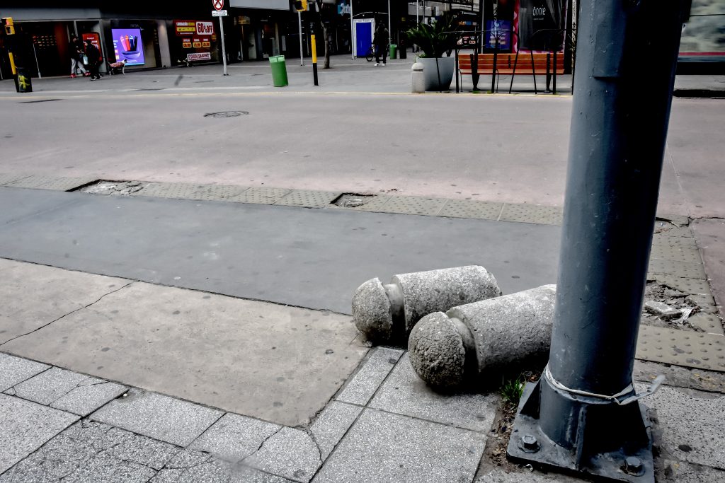 En cada esquina hay uno o más pilotes de cemento derribados.