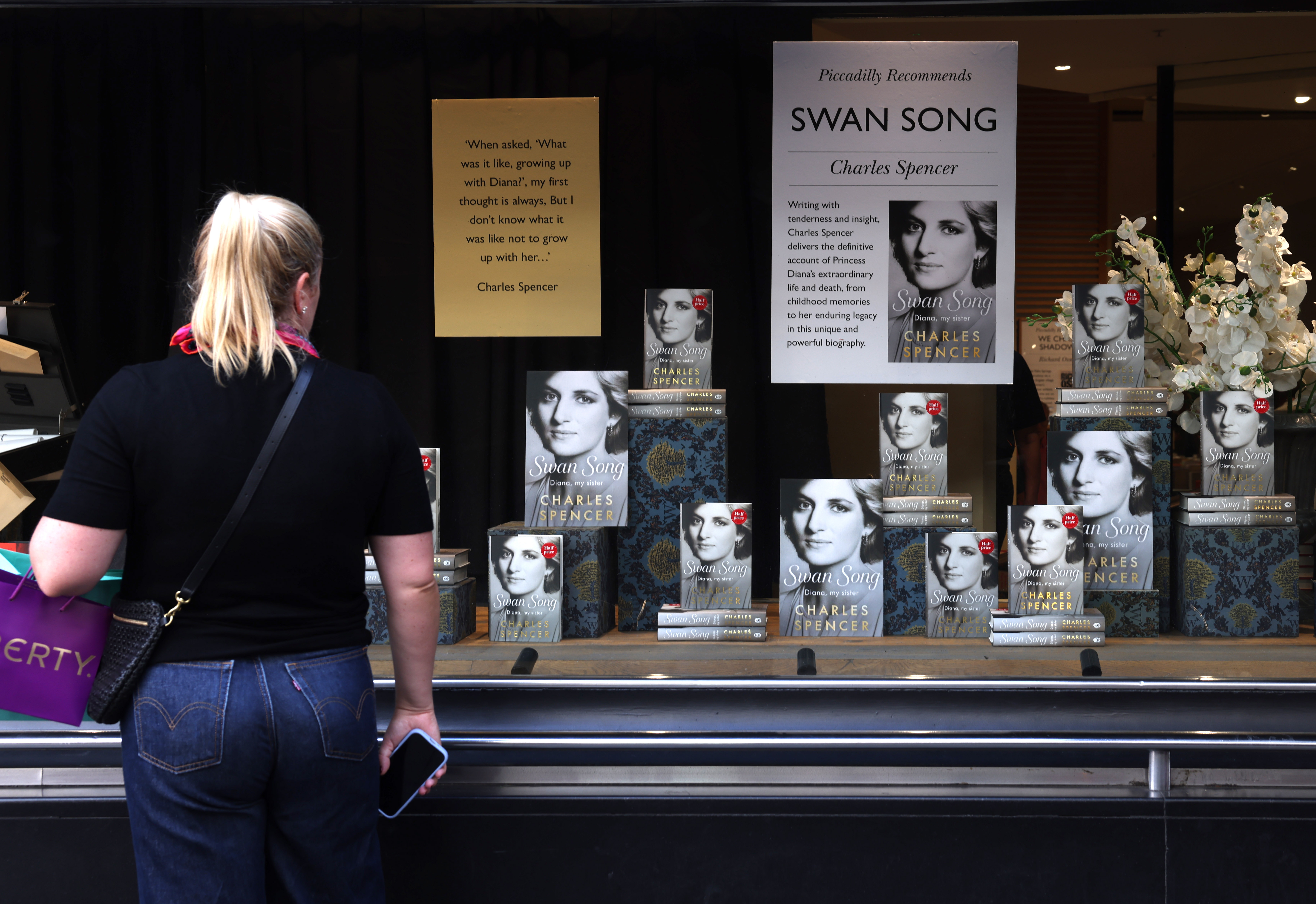 Una mujer frente a una librería Waterstones donde se exhiben ejemplares de "Swan Song: Diana, My Sister" (El canto del cisne: Diana, mi hermana). Foto: EFE | EPA | Neil Hall.