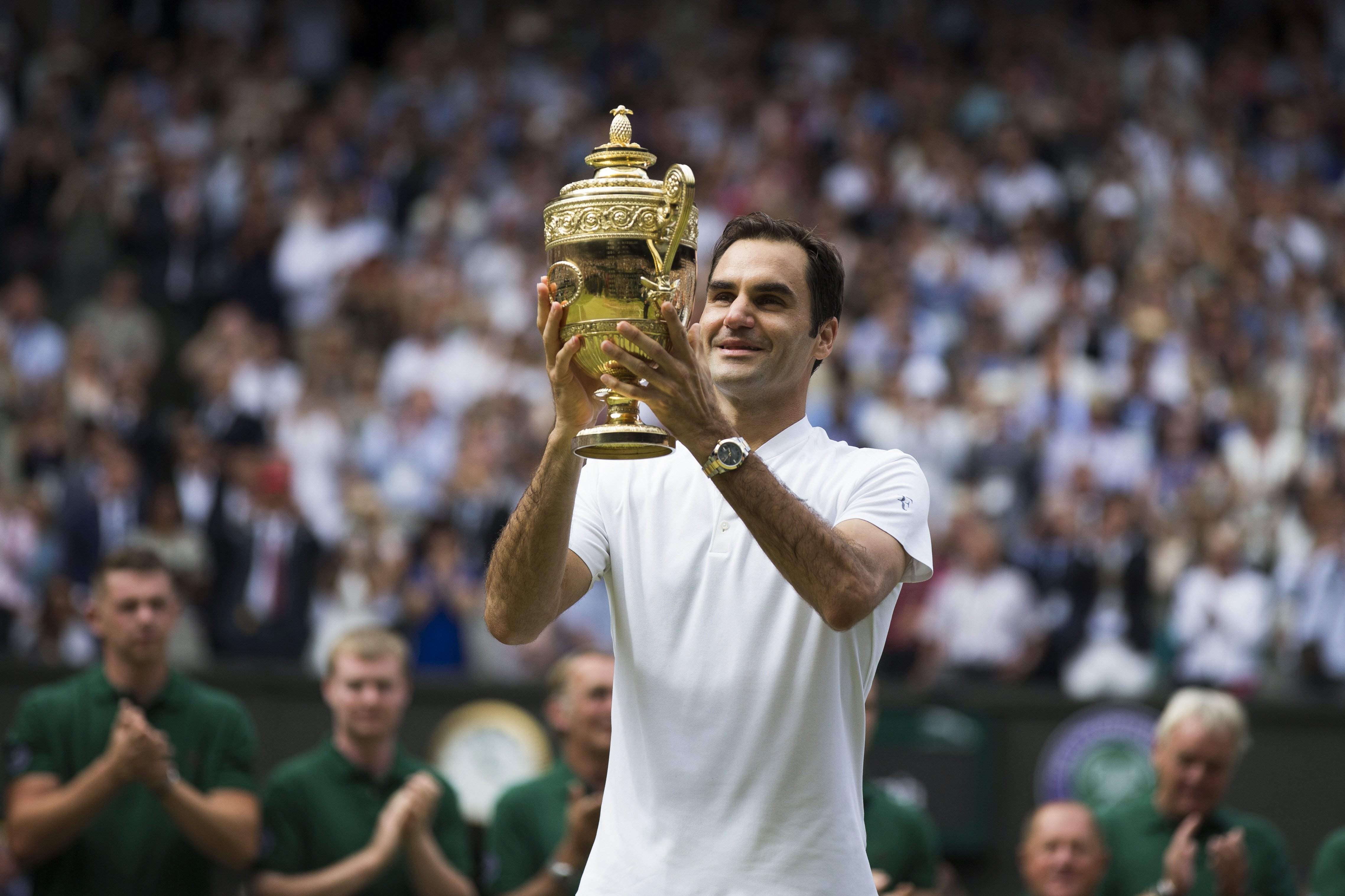 Federer y el trofeo que la acredita como campeón de Wimbledon en el All England Lawn Tennis Club. Foto: EFE / EPA / Peter Klaunzer.