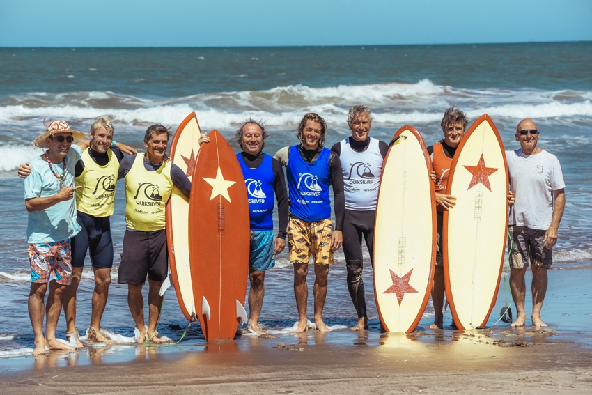  Fernando Aguerre y el shaper Renato Tiribelli posan a los costados junto a surfistas de distintas edades y las cuatro tablas retro hechas para la ocasión.
