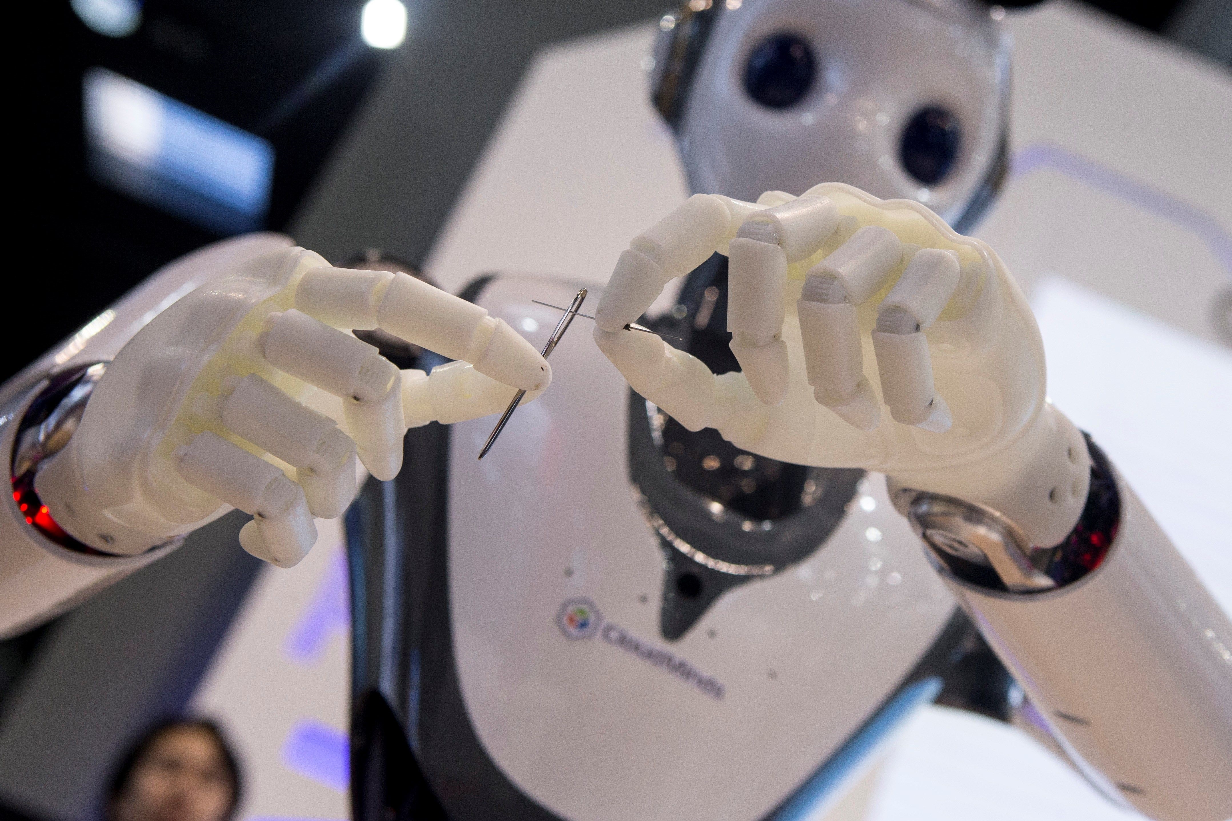 El robot humanoide de la empresa Cloudminds, Nicole, enhebra una aguja. Foto: EFE | Quique García.
