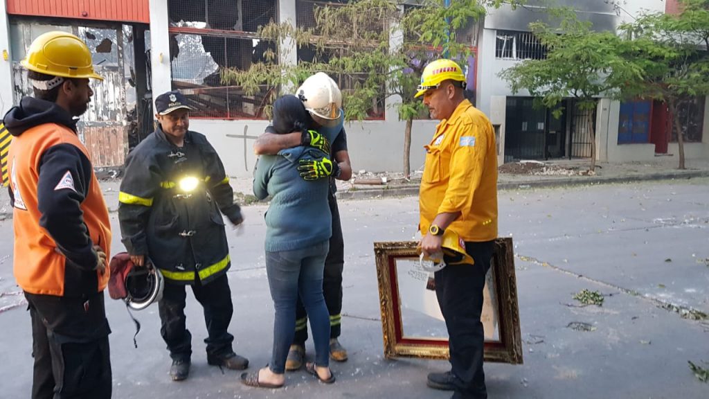 El conmovedor abrazo entre la mujer y el bombero que encontró la urna y la foto del nene fallecido.