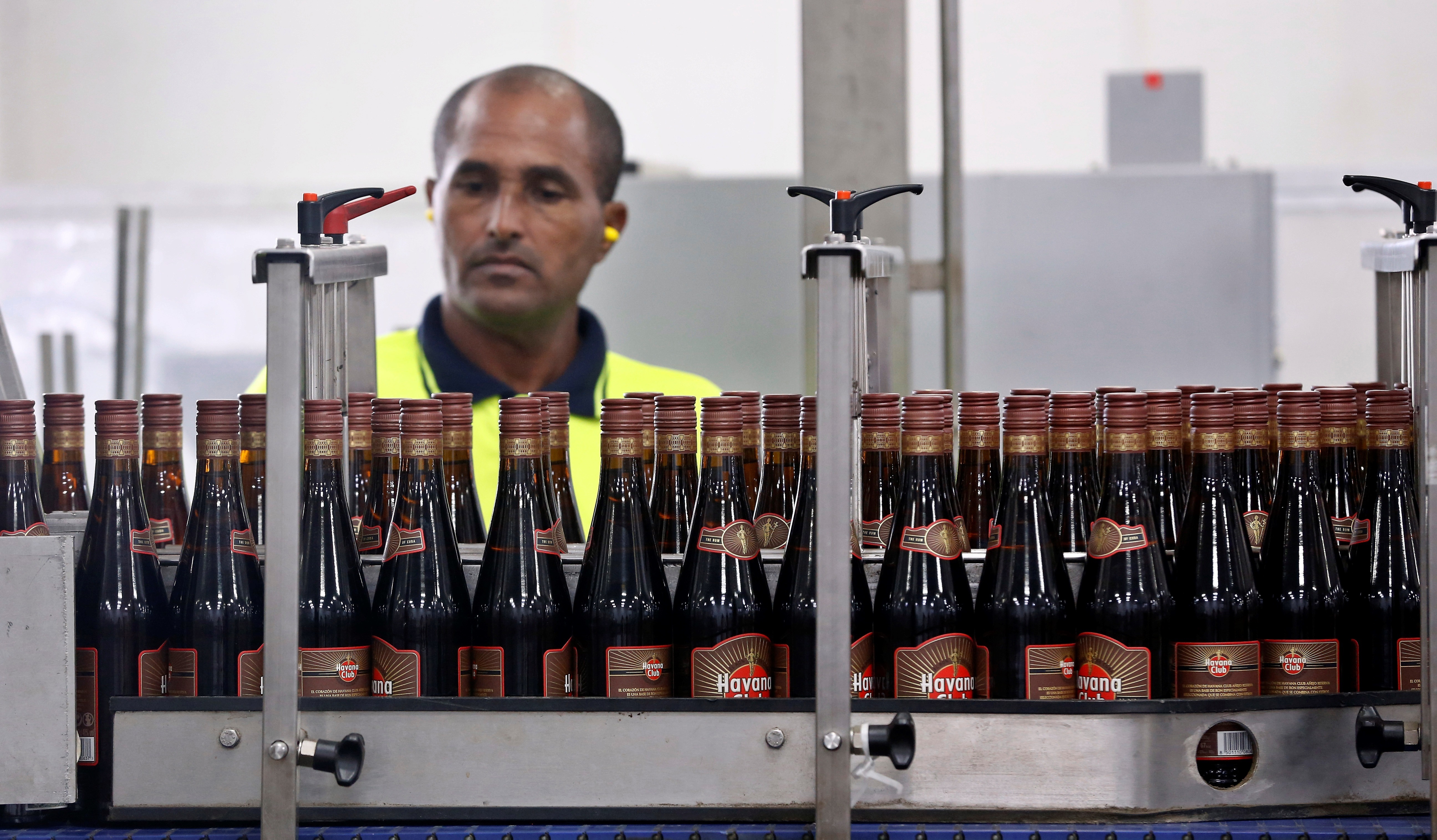 Un trabajador realiza un examen de calidad a las botellas de ron Havana Club, en la Fábrica de Ron de San José de las Lajas. Foto: EFE | Ernesto Mastrascusa.
