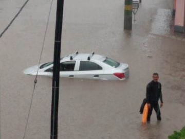 Un auto con el agua hasta casi llegar a las ventanas, en Caraza y Florencio Sánchez