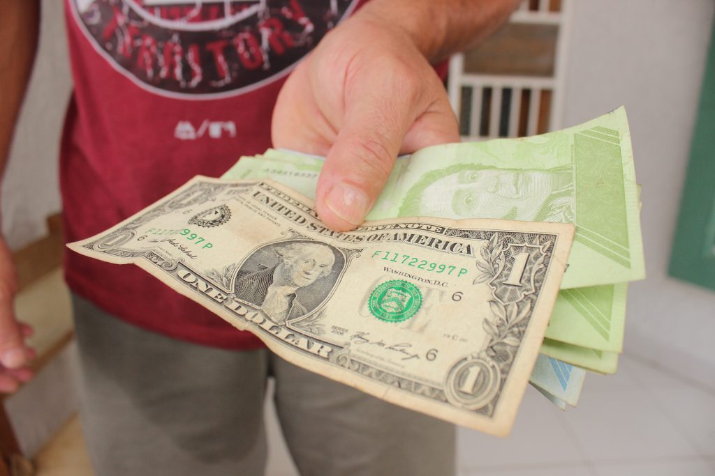Una persona muestra bolívares y dólares, en San Cristóbal, Táchira. Foto: EFE | Johnny Parra.