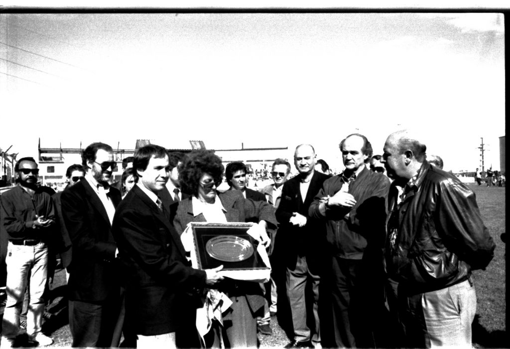 Oscar Salerno entrega una plaqueta a la viuda de Adolfo López durante el acto inaugural.