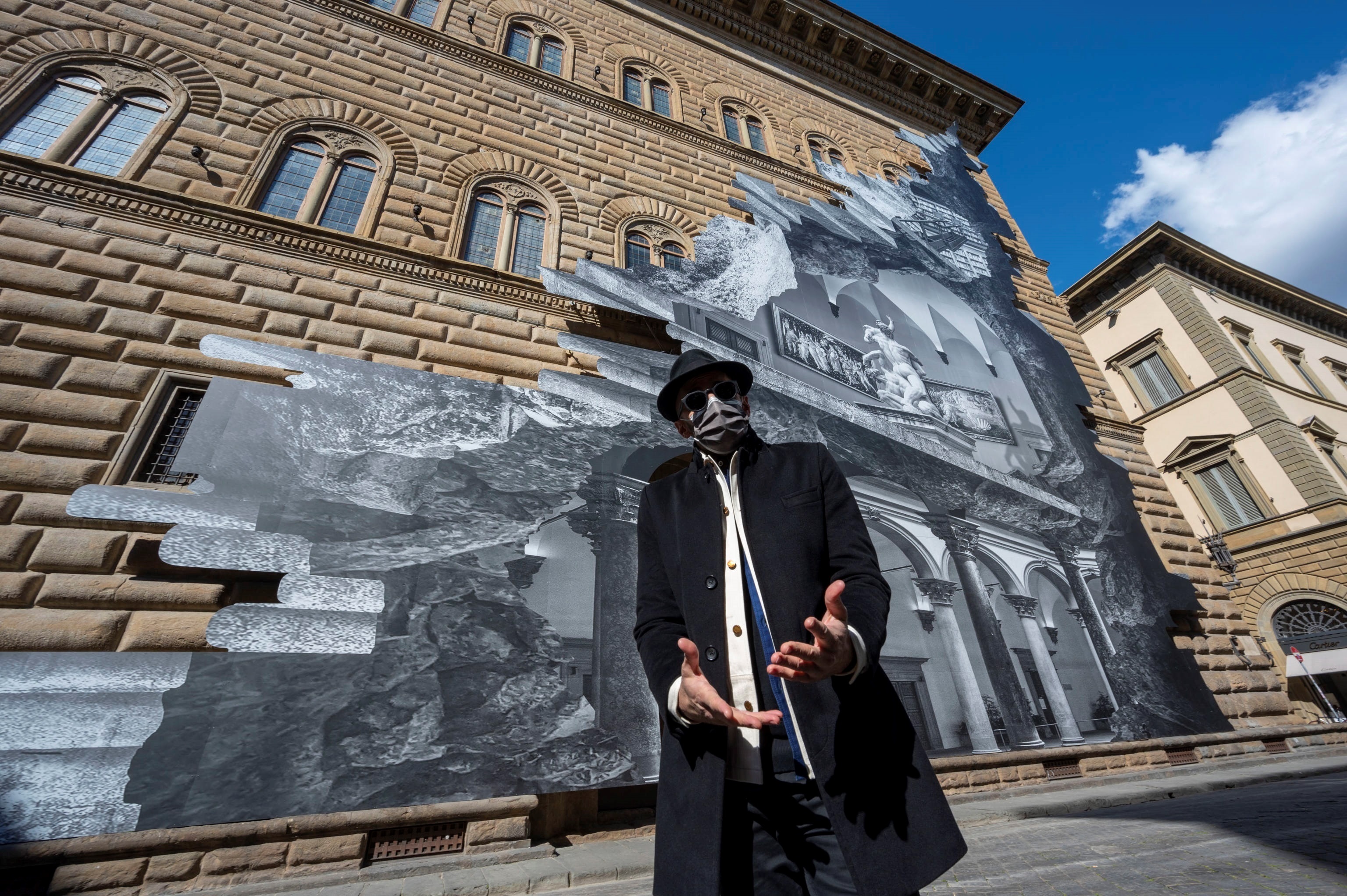 El artista francés JR posa durante la inauguración de su instalación visual 'La herida' en la fachada del Palazzo Strozzi, en Florencia. Foto: EFE | EPA | Claudio Giovaninni.