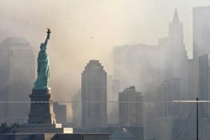 Smoke from the remains of New York's World Trade Center shrouds lower Manhattan as the Statue of Liberty stands in the foreground in this image taken across New York Harbor from Jersey City, New Jersey, September 12, 2001. Each of the twin towers were hit by hijacked airliners and collapsed in one of numerous acts of terrorism directed at the United States September 11, 2001.   REUTERS/Ray Stubblebine