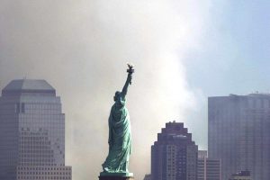 Smoke and ash from the destroyed World Trade Center rise over the southern end of New York City's Manhattan behind the Statue of Liberty as seen from Jersey City, New Jersey 12 September 2001. Terrorists hijacked two commercial airliners and crashed them into each of the towers of the Trade Center, collapsing them.    AFP Photo/Tannen MAURY