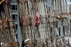 Workers in a crane bucket use torches to cut away pieces of the last remaining standing portions of the facade of the wreckage of the World Trade Center towers in New York, September 27, 2001. It has been more than two weeks since the September 11 attacks on the landmark World Trade Center towers that caused their collapse.     REUTERS/Mike Segar