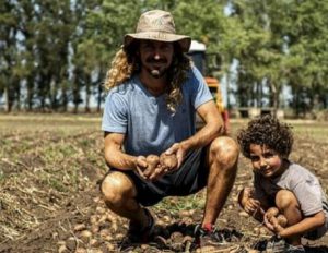 Marque junto a su hijo durante una cosecha de papa agroecológica.