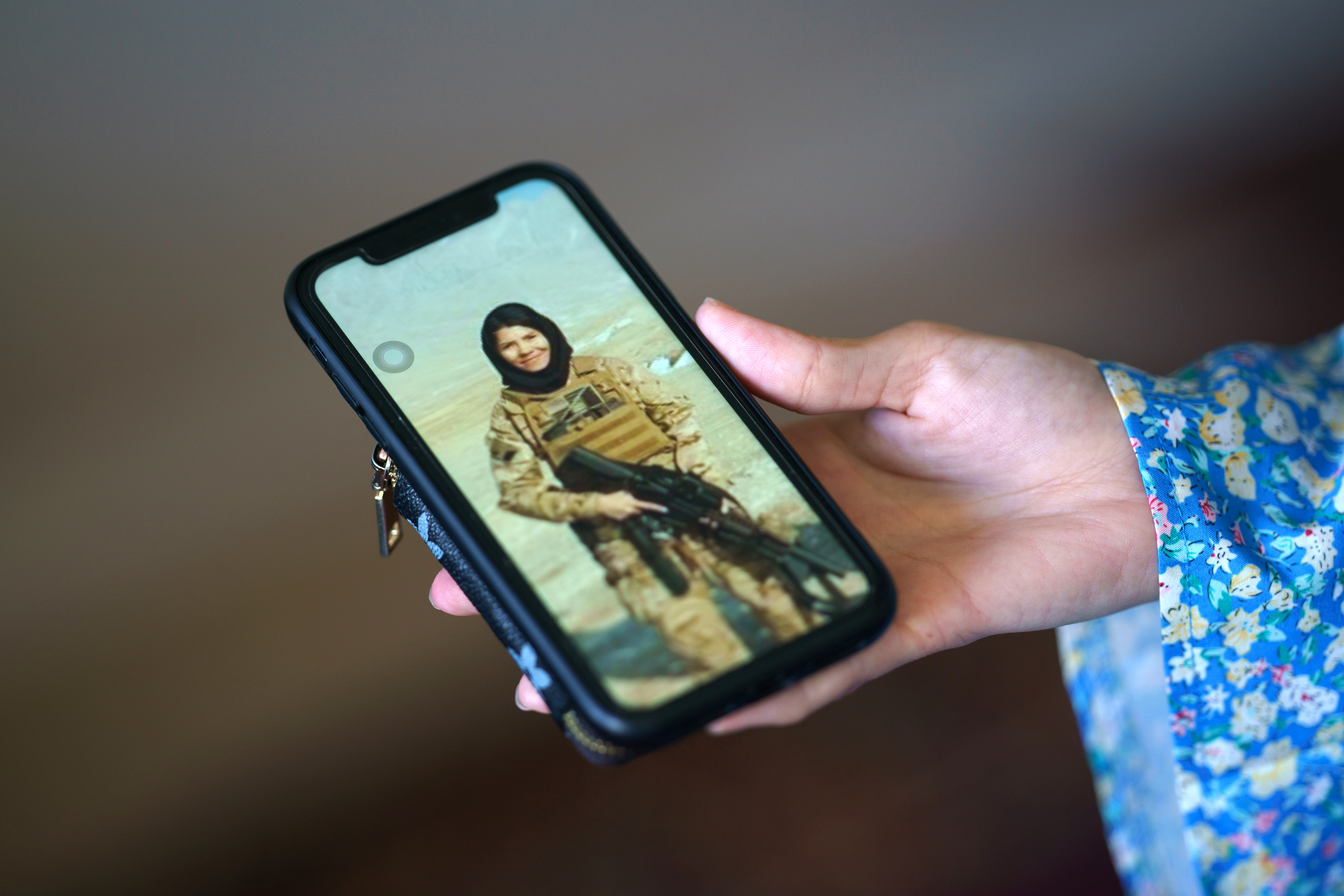Mahnaz Akbari muestra un teléfono móvil con una foto suya con uniforme militar. Foto: EFE | Will Oliver.
