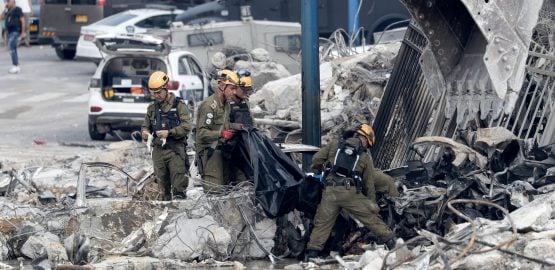 Fuerzas de seguridad israelíes retiran un cadáver frente a la comisaría destruida que estaba controlada por militantes de Hamas en Sderot, cerca de la frontera con Gaza. Foto: EFE | EPA | Atef Safadi.