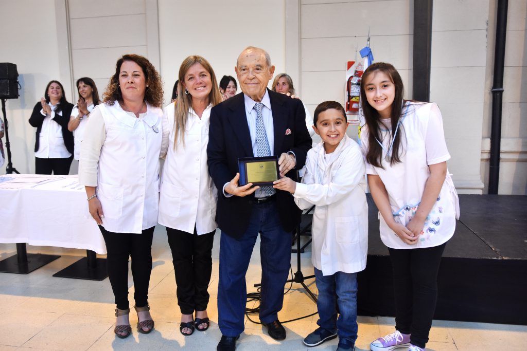 Los egresados Antonella y Felipe fueron los encargados de entregarle la plaqueta homenaje al padrino de la Escuela Primaria N°1, el empresario Florencio Aldrey.