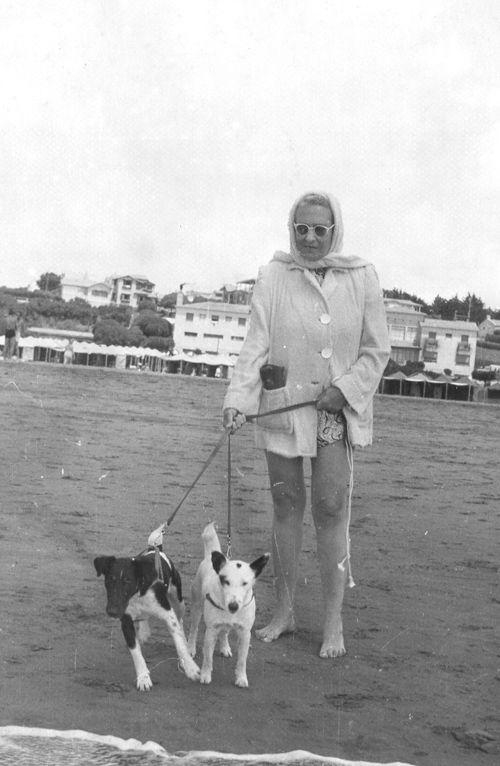 Victoria Ocampo posa con sus icónicos anteojos de marco blanco, paseando a dos perros en Punta Mogotes, un 28 de enero de 1956. / Foto exhibida en la muestra "Victoria, sus pasos en nuestra ciudad".