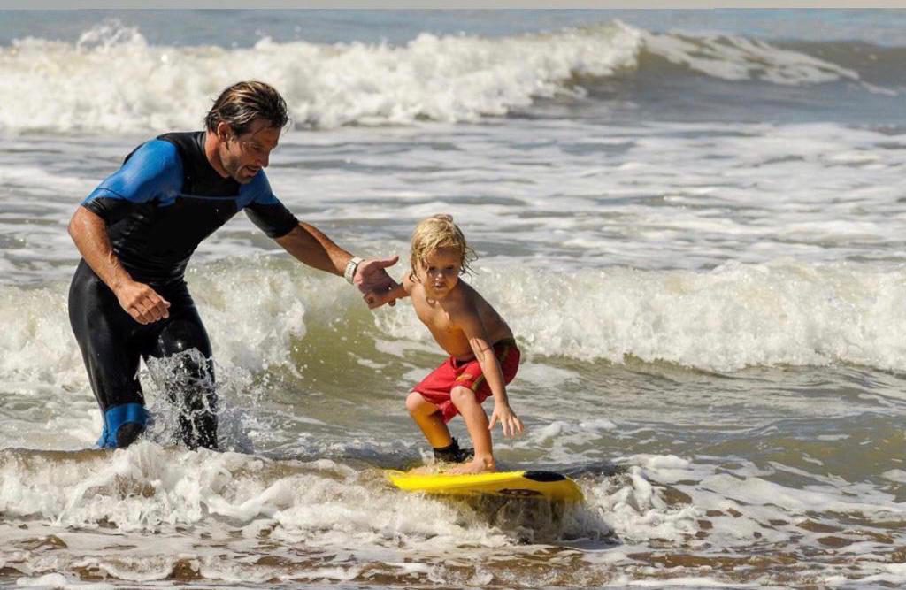 Martín enseñando a surfear a Thiago hace 12 años.