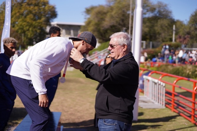 Foto: Alejandro Salgado/COA. El presidente del COA durante la premiación de Elián Larregina, quien ganó la medalla de plata en los 400 metros llanos.