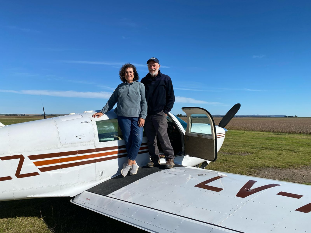 La pareja de aventureros posa sobre su avión monomotor Mooney M20J, modelo 1978.