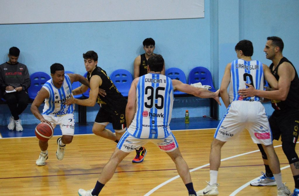 El base panameño Guillermo Navarro busca la ayuda del bloqueo de Juan Ignacio Bellozas para escapar de la marca de Piero Di Prinzio.