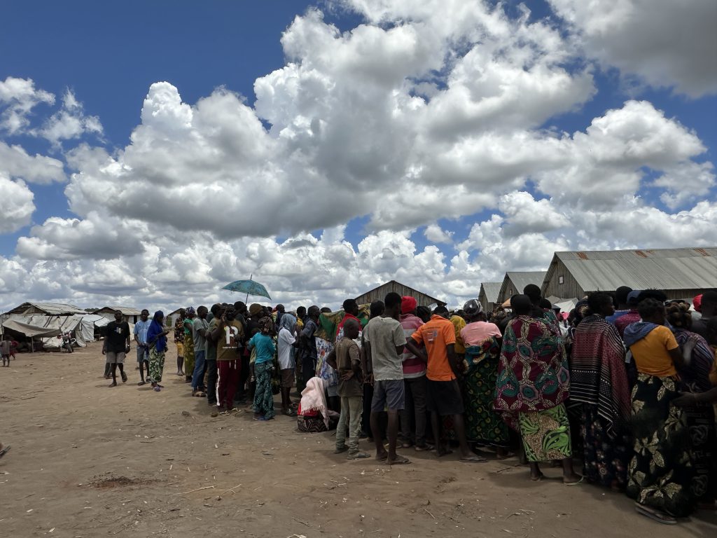 Residentes del campamento de desplazados de Lianda, en el distrito de Mueda, se reúnen antes de una distribución. Lianda es el campamento más grande en términos de superficie y número de residentes, con más de 3.000 familias desplazadas al 13 de octubre de 2025. Muchas han llegado recientemente desde Mocímboa da Praia, huyendo de la última ola de violencia que ha afectado repetidamente a la ciudad desde principios de septiembre.