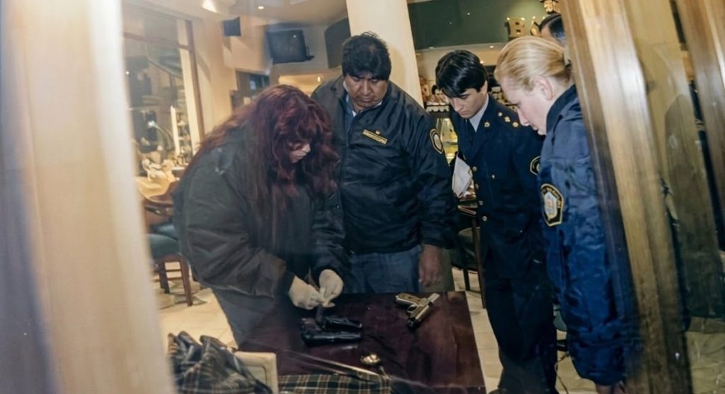 Personal policial revisa las tres armas secuestradas en el lugar.