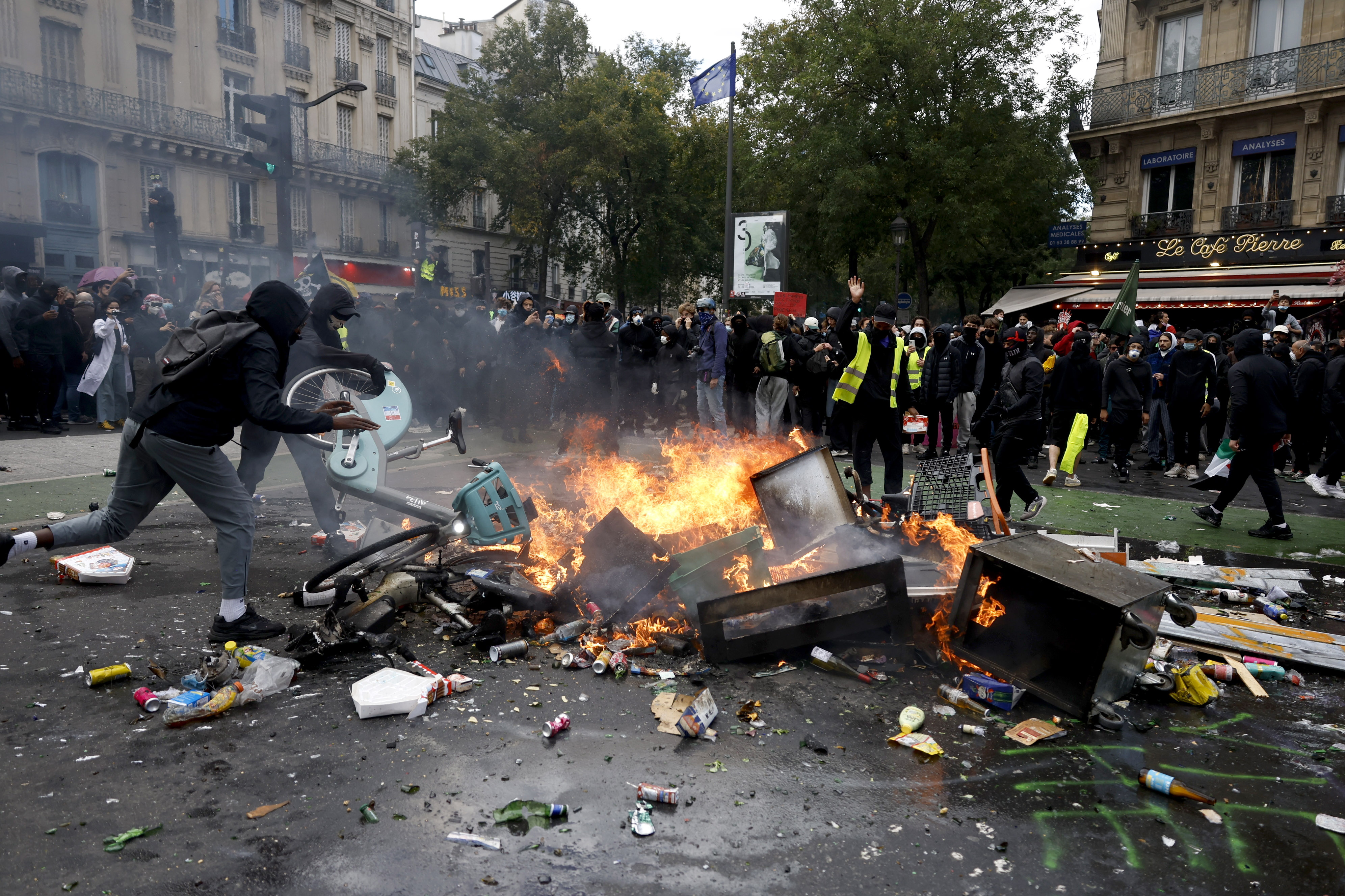 Manifestantes arrojan bicicletas eléctricas a un contenedor de basura en llamas durante una protesta en París. Foto: EFE | EPA | Yoan Valat.